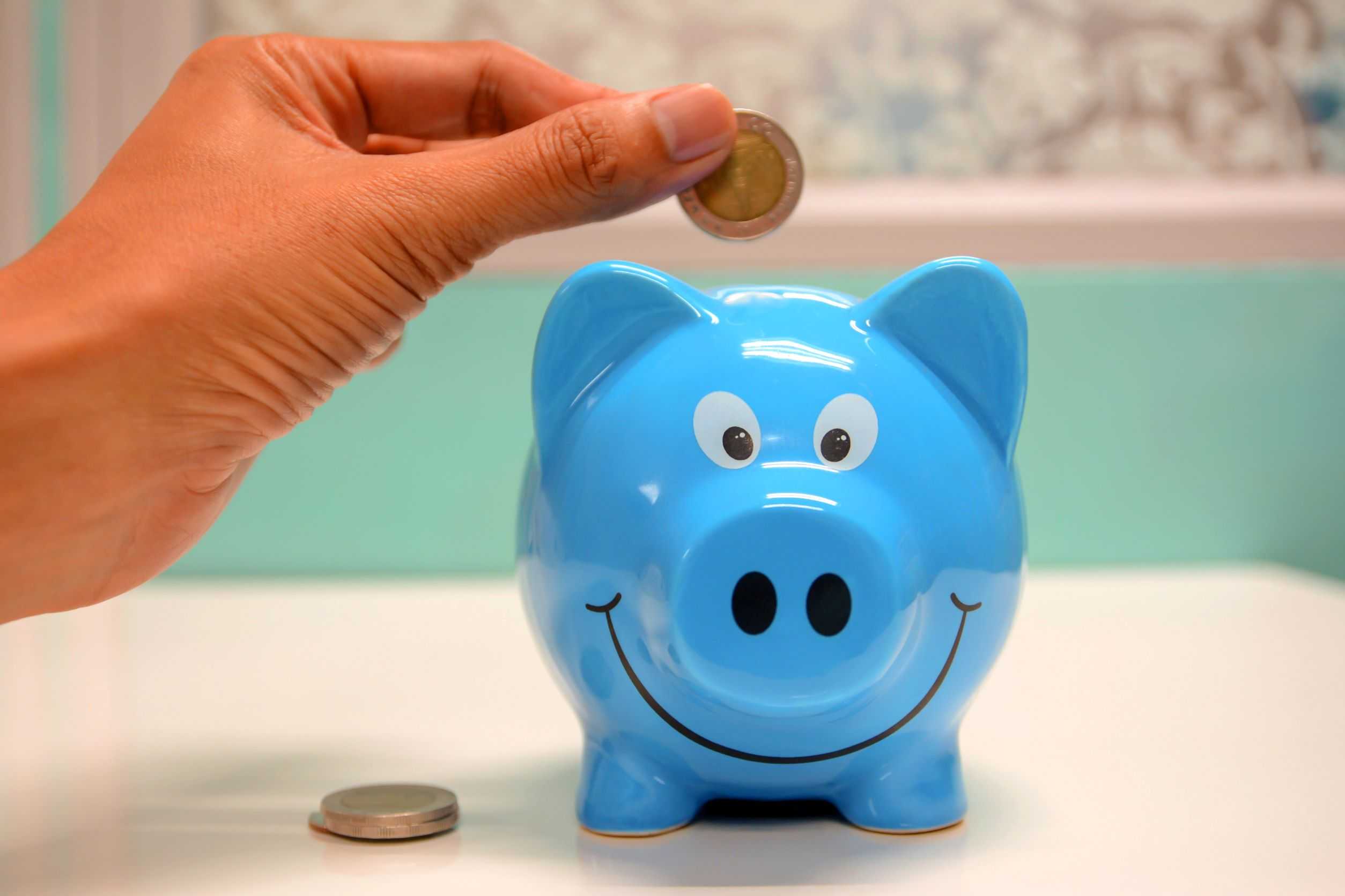 Throwing coin into piggy bank